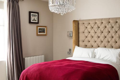 um quarto com uma cama grande e um cobertor vermelho em The George at Backwell em Nailsea