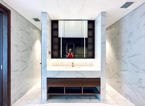 a person taking a picture of a bathroom sink at THE METROPOLE Apartment Complex OPERA-GALLERIA-CREST in Ho Chi Minh City