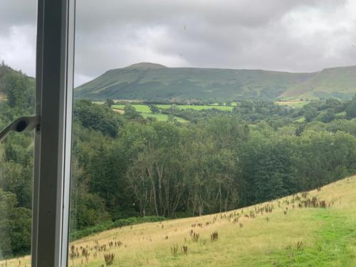 a view from a window of a field with trees at Black Mountain Family Room in Velindre