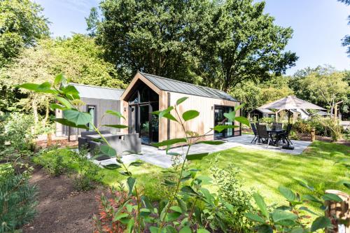 a tiny house in a garden with a patio at TopParken - Résidence Lage Vuursche in Lage-Vuursche