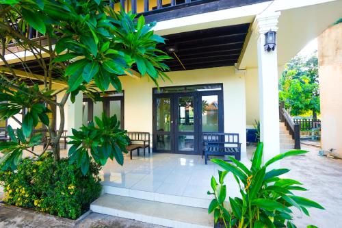 a front door of a house with plants at Mr Tho's Bungalows in Don Det