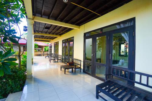 a porch of a building with benches and windows at Mr Tho's Bungalows in Don Det