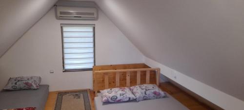 a small attic room with a bed and a window at Aura natura in Visoko