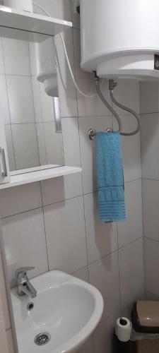 a bathroom with a white sink and a blue towel at Aura natura in Visoko
