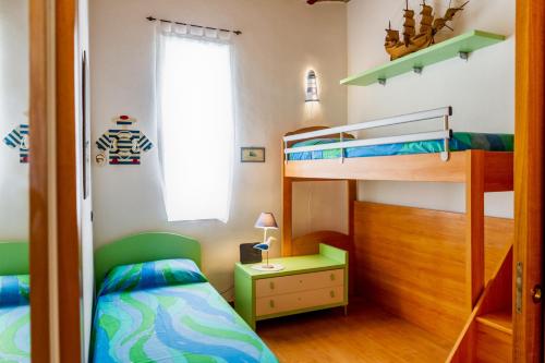 ポルト・エルコレにあるCasa Nanàのベッドルーム1室(二段ベッド2台、窓付)が備わります。
