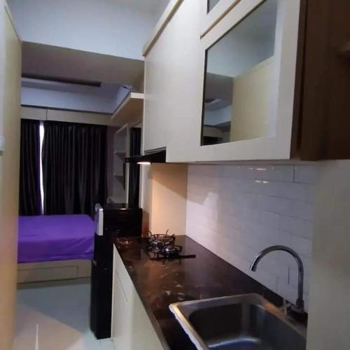eine Küche mit einem Waschbecken und ein Bett in einem Zimmer in der Unterkunft Andalemi Home Stay in Ciwidey