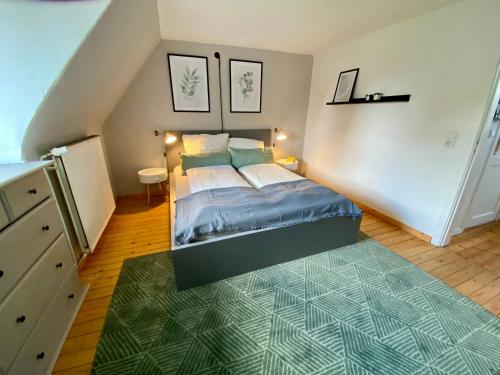 a bedroom with a bed and a green rug at Haus No. 16 in Ratzeburg