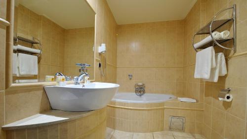 y baño con lavabo blanco y bañera. en Hotel Diament Bella Notte Katowice - Chorzów, en Chorzów