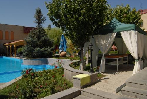 una piscina con un ombrellone e un tavolo e una piscina di Armenian Royal Palace a Yerevan