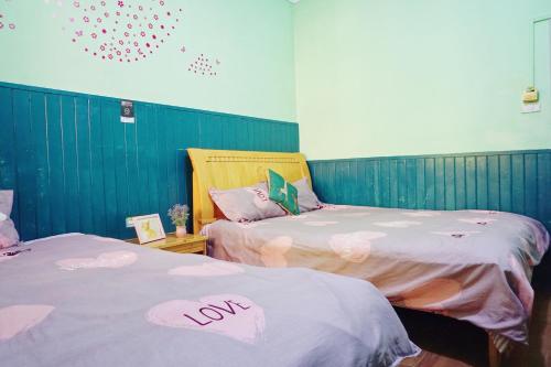 dwa łóżka ze słowem "miłość" na nich w obiekcie 桂林时光驿青年客栈 w mieście Guilin