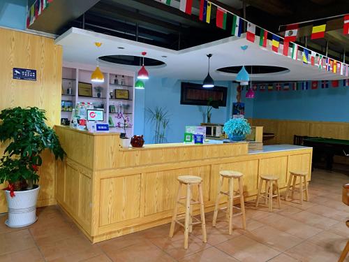 a restaurant with a wooden counter and stools at 桂林时光驿青年客栈 in Guilin