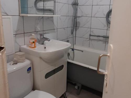 a bathroom with a sink and a toilet and a tub at Эконом вариант - квартира в центре из первых рук in Chernihiv