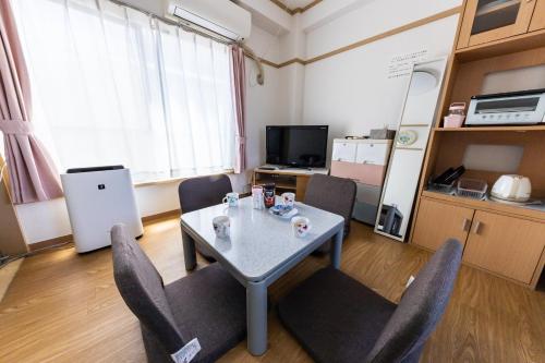 a room with a table and chairs and a kitchen at ヴァンベール晃永2 in Tokyo