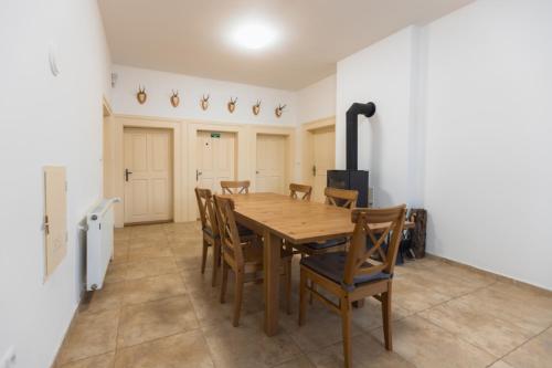 a dining room with a wooden table and chairs at Hájenka Budislav in Budislav