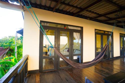 a hammock hanging from the side of a house at Mr Tho's Bungalows in Don Det