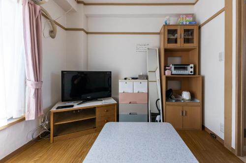 a small room with a tv and a desk with a television at ヴァンベール晃永2 in Tokyo