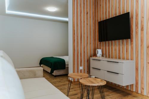 a room with a bed and a tv on a wall at Vila K2 in Vrdnik