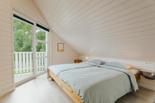 een witte slaapkamer met een bed en een groot raam bij Sorgenfrei in Brasilien