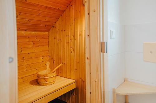 - un sauna en bois avec un panier en bois sur une étagère dans l'établissement Sorgenfrei, à Brasilien