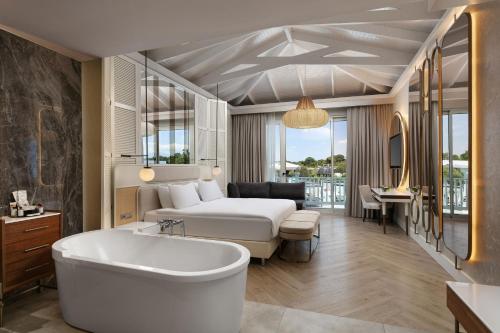 a bedroom with a bed and a tub in a room at Titanic Deluxe Golf Belek in Belek