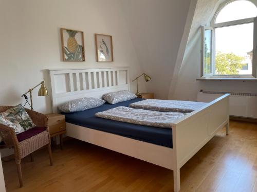 a bedroom with a bed and a chair and a window at Haus am Seerhein in Konstanz