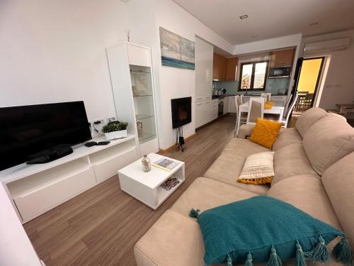 a living room with a couch and a flat screen tv at Villa Bigoude, Figueira da Foz in Figueira da Foz