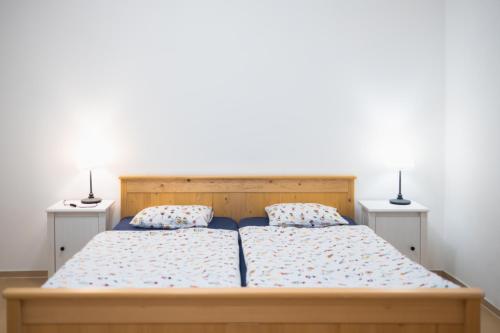 a bedroom with a bed with two lamps on it at Hájenka Budislav in Budislav