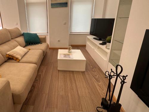 a living room with a couch and a tv at Villa Bigoude, Figueira da Foz in Figueira da Foz