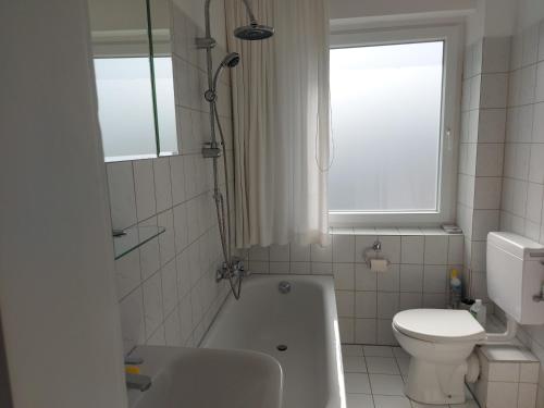 y baño con bañera, aseo y lavamanos. en Ferienwohnung Hiddesen en Detmold