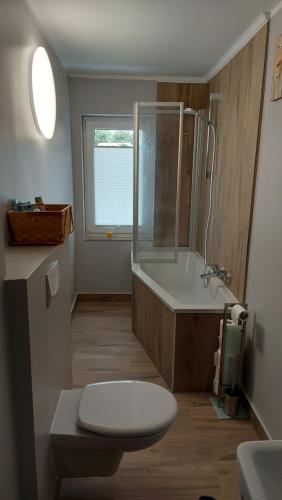 a bathroom with a tub and a toilet and a sink at Ferienwohnung Otto nähe Stralsund in Abtshagen