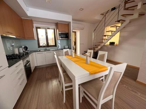 a kitchen with a white table and white chairs at Villa Bigoude, Figueira da Foz in Figueira da Foz