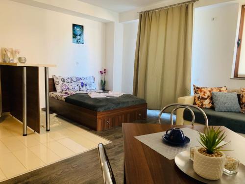 een woonkamer met een bed en een tafel bij FourSeasonsApartments in Braşov