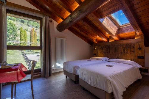 a bedroom with a bed and a large window at Eco Dimora Baltea - Affittacamere al Verde villaggio di Rumiod in Saint-Pierre