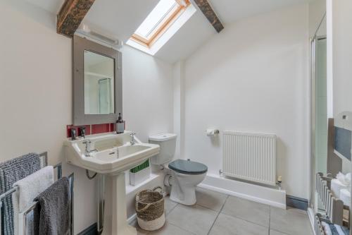 a bathroom with a sink and a toilet and a mirror at Buff Lodge in Tackley