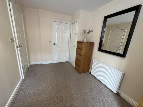 um corredor com um espelho e uma cómoda num quarto em Alexander Apartments South Shields 2 em South Shields