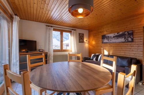 ein Esszimmer mit einem Holztisch und Stühlen in der Unterkunft Hôtel Les Côtes, Résidence Loisirs et Chalets in Morzine