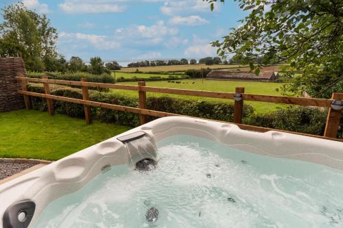 a bath tub with a faucet in a yard at Wallhope Retreat in Chepstow