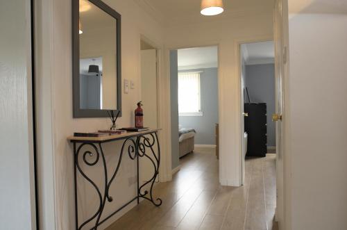 um corredor com uma mesa, um espelho e um quarto em Modern 2-Bed Haven, FREE PARKING em Edinburgo