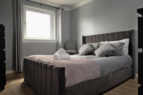 um quarto com uma cama grande e uma janela em Modern 2-Bed Haven, FREE PARKING em Edinburgo
