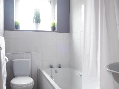 een badkamer met een bad, een toilet en een wastafel bij Pass the Keys Flat close to amenities in Scunthorpe