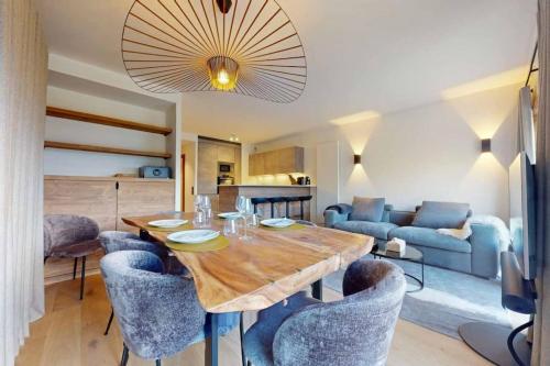 uma sala de estar com uma mesa de madeira e cadeiras em Appartement neuf à Mottaret / A12 em Les Allues