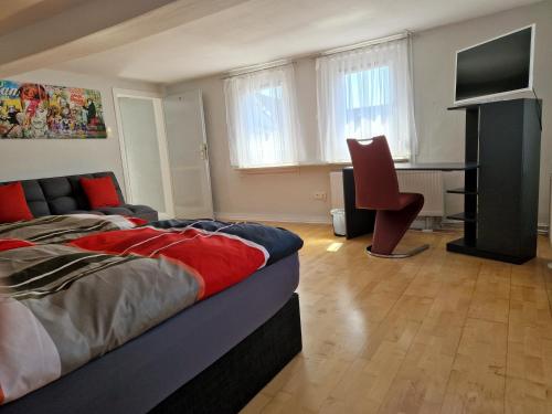 sypialnia z łóżkiem, biurkiem i telewizorem w obiekcie Föller´s Gästehaus w mieście Neu-Anspach