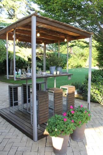 a gazebo with a table and chairs and flowers at Hebe Home Riccione in Misano Adriatico