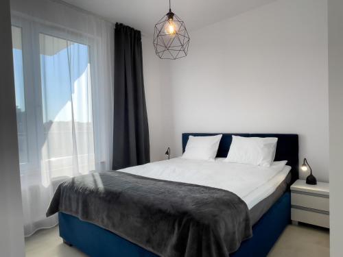 ein Schlafzimmer mit einem großen Bett und einem Fenster in der Unterkunft URBAN APARTMENTS Premium DOWNTOWN Opolska 10 No 77A with GARAGE in Kattowitz