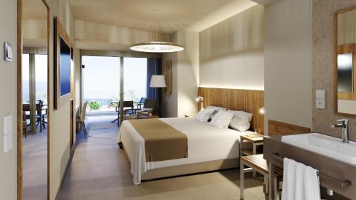 een slaapkamer met een bed en een badkamer met een wastafel bij BANCAL HOTEL and SPA in San Sebastián de la Gomera