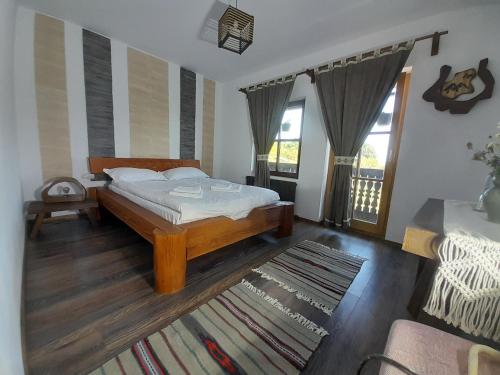 a bedroom with a bed and a living room at Mosia Dar In Rai in Berbeşti