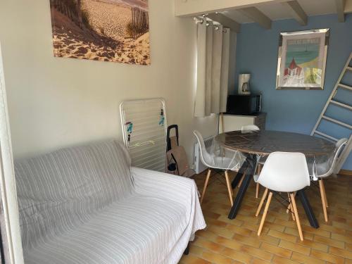 un soggiorno con letto, tavolo e sedie di Appartement Classé 1 * au calme, 300m de l'océan a Soulac-sur-Mer