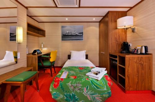 ein Hotelzimmer mit einem Bett, einem Schreibtisch und einem Tisch in der Unterkunft ss Rotterdam Hotel en Restaurants in Rotterdam