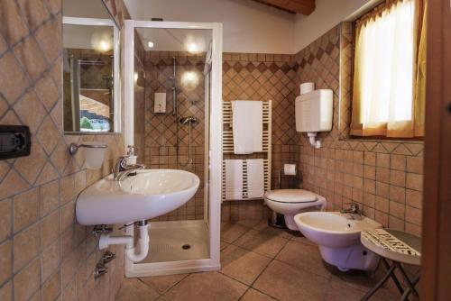 a bathroom with two sinks and a toilet at Agriturismo San Maggiore in Malcesine