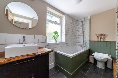 a bathroom with a sink and a tub and a toilet at The Finsbury Park Collection in London